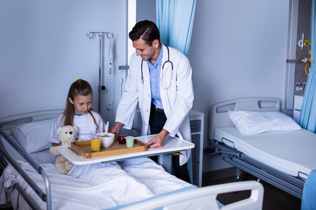 Doctor serving breakfast to girl