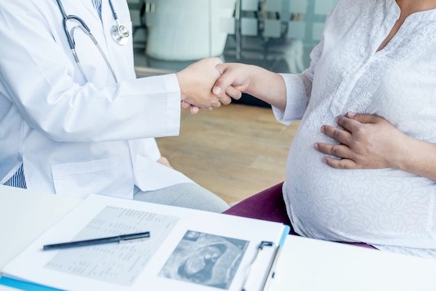 The doctor shake hand after check the health and advise pregnancy to pregnant women.