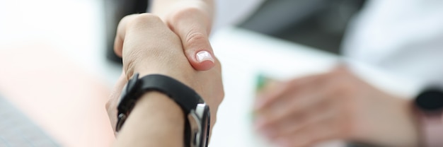 Doctor shaking hand with patient in office closeup