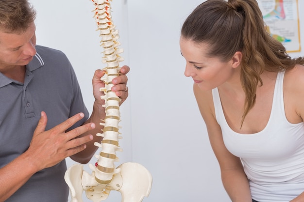 Doctor showing anatomical spine to his patient 