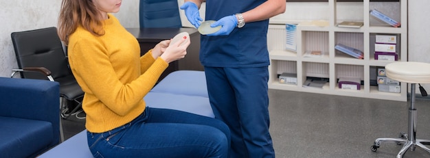 Doctor showing breasts implants to female patient