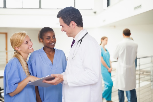 Doctor showing a clipboard to nurses