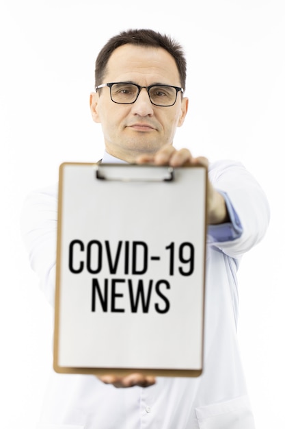 Covid-19ニュースの碑文と医師表示クリップボード。コロナウイルスパンデミック