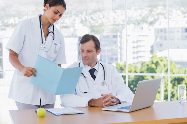 Doctor showing a folder to a colleague