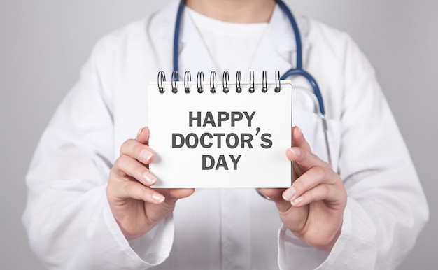 Doctor showing Happy Doctor's Day on notepad