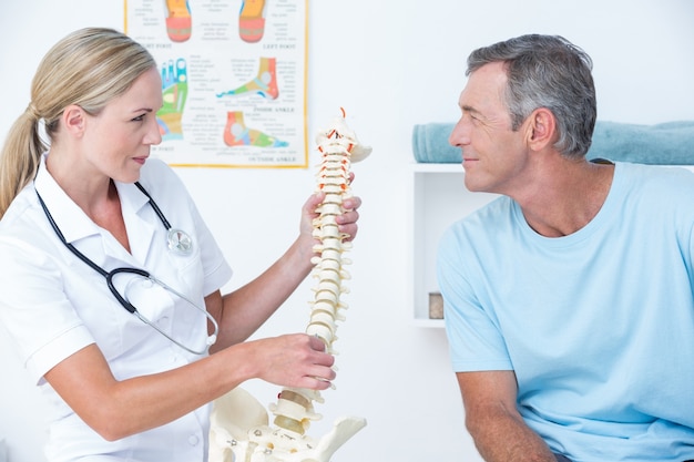 Doctor showing her patient a spine model