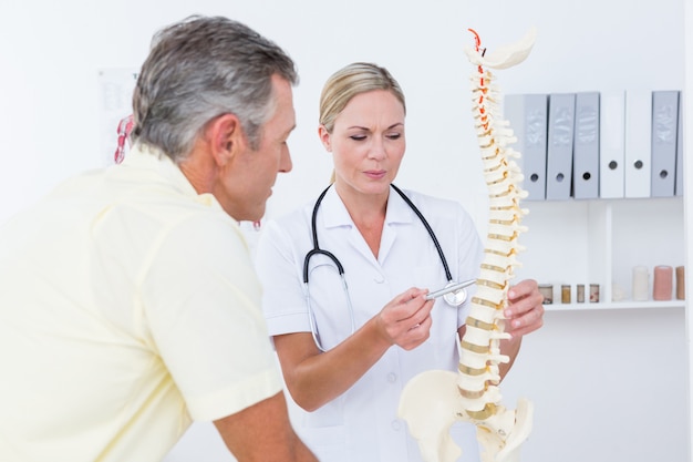 Doctor showing her patient a spine model