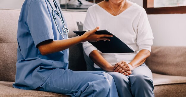 Photo doctor showing medical card to patient at table in clinic closeup