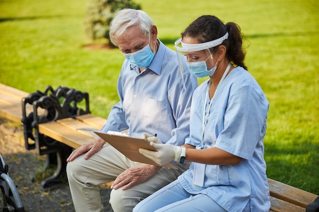 Doctor showing notes on file folder for old patient