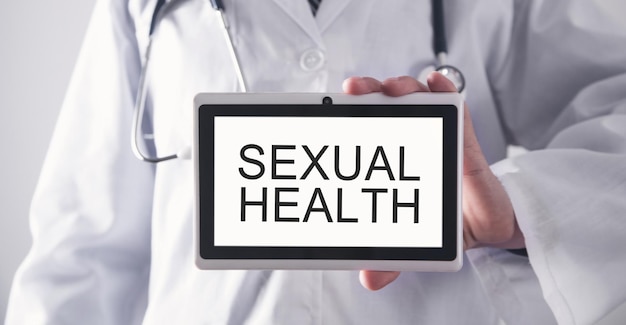 Doctor showing Sexual Health text in tablet screen.