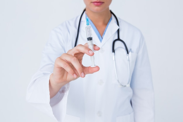 Doctor showing syringe to camera