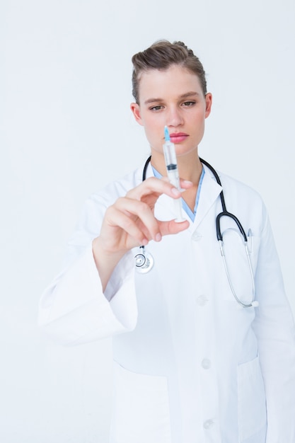 Doctor showing syringe to camera