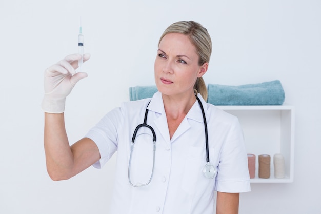 Doctor showing syringe to camera