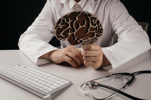 Photo doctor showing wooden brain model