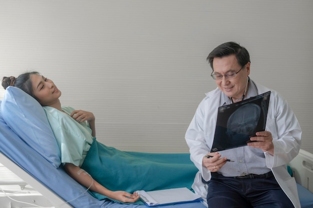 Foto dottore che mostra i raggi x al paziente mentre è seduto in ospedale