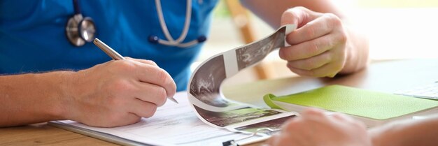 Doctor shows patient results of ultrasound scan to female patient medical ultrasound scan