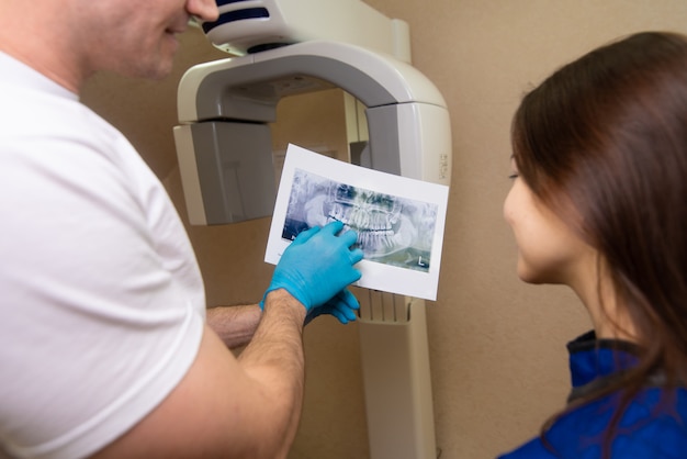 The doctor shows the patient an x-ray image. Computer diagnostics