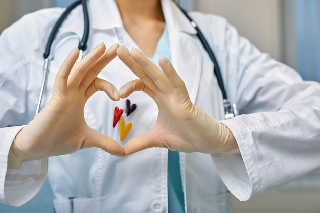 Doctor shows simbols of heart through the hands folded in the shape of a heart with medical care concept, Medicine in hospital, cardiology.