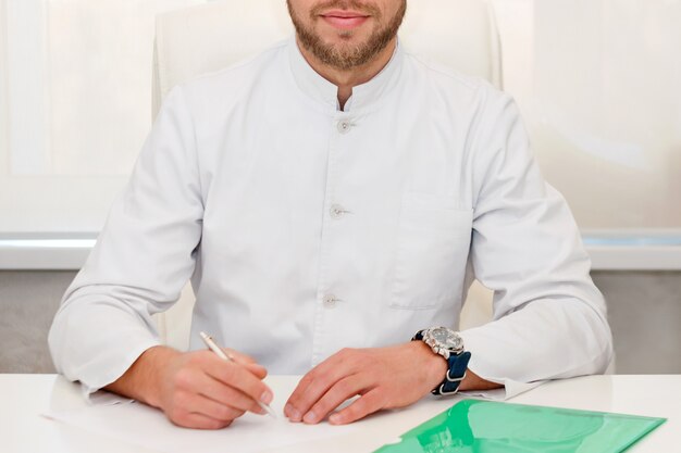 Doctor sitting at the table in consulting room. Medical clinic or hospital healthcare service center. Medical technology concept.