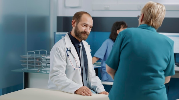 Photo doctor sitting with patient at hospital