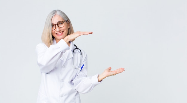 Doctor smiling, feeling happy, positive and satisfied, holding something