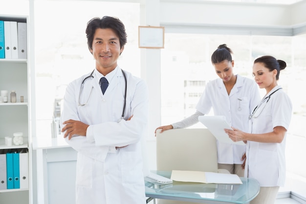 Dottore sorridente davanti a colleghi di lavoro