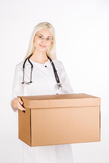 Doctor smiling holding box and looking at camera image on a white studio background