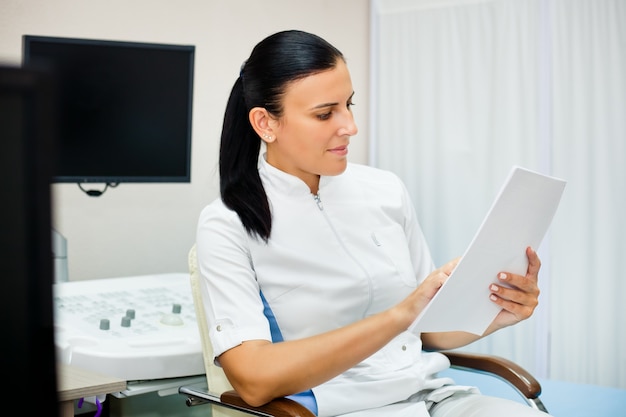 Doctor smiling while studying a medical history