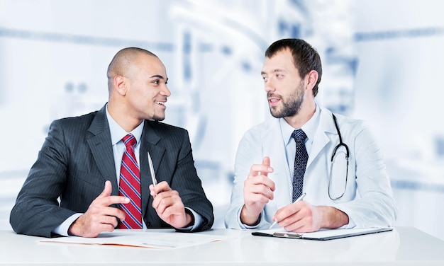 Doctor smiling with male patient sitting at the table