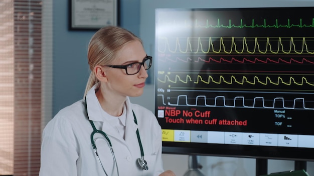 Doctor standing by computer in hospital