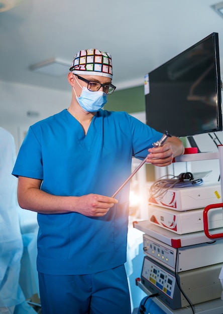 Doctor standing in medical chamber with instrument. Medical male portrait. Medical concept. Vertical photo.