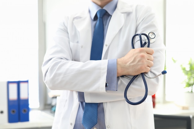 Doctor standing in office with stethoscope in hand