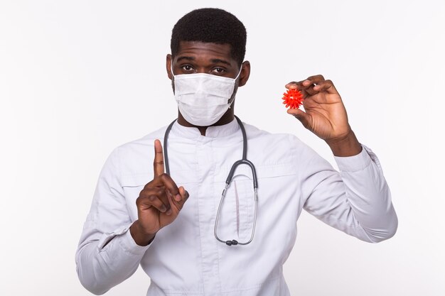 Doctor in sterile gloves holding a mockup of virus of COVID-19 as dangerous flu strain cases as a pandemic