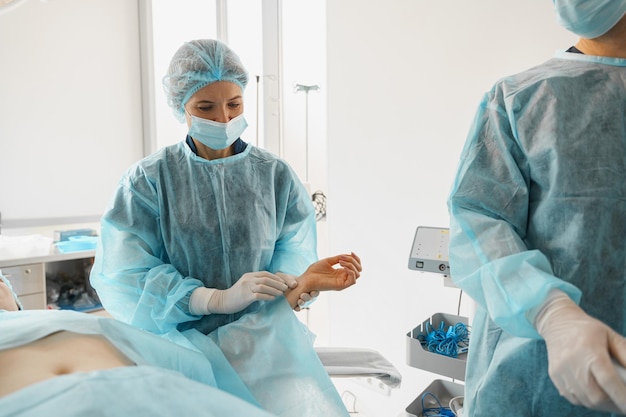 Doctor surgeon checking patient pulse during surgery in operation room