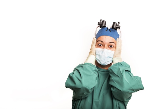 Doctor surgeon shocked funny Woman closeup portrait of young doctor surgeon or nurse surprised starring with big eyes wearing surgical mask