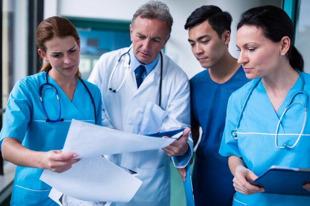 Doctor and surgeons discussing with report in surgical room