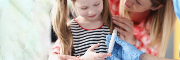 Doctor takes blood test with lancet from little girl