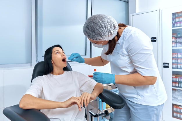 The doctor takes a smear for a PCR test from a young woman