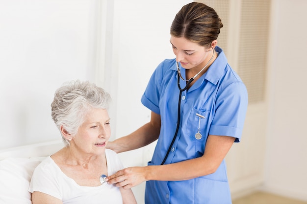 Doctor taking care of suffering senior patient at home