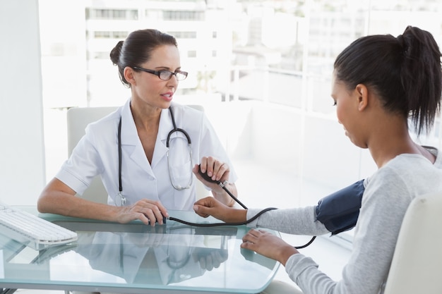 Doctor taking patients blood pressure