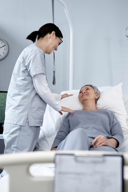 doctor talking to old woman in ward