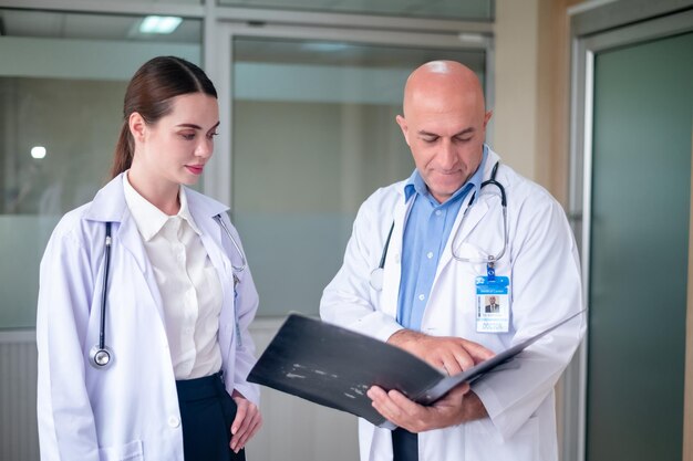 Doctor talking with woman doctor at hospital meeting room