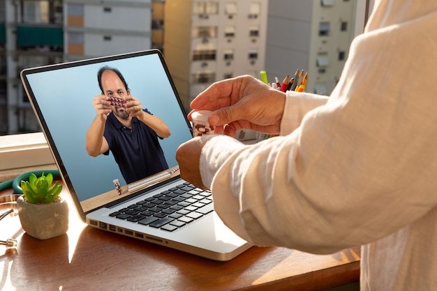 Foto il dottore parla al suo paziente tramite teleconferenza