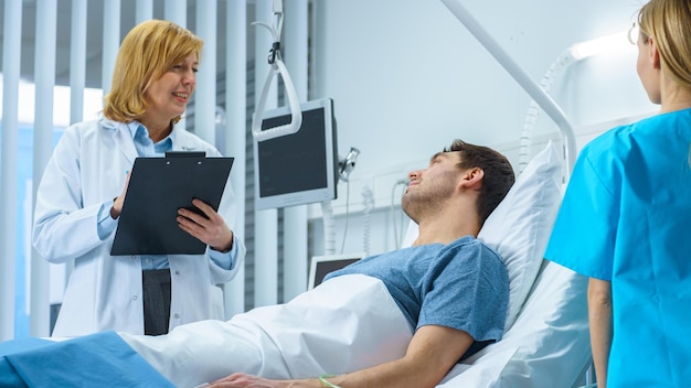 Photo a doctor talks to a patient in a hospital bed.