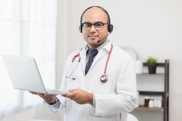 Врач разговаривает с пациентом через онлайн-видеоконференцсвязь с ноутбуком в гарнитуре Объясняет о приеме лекарств для лечения болезней