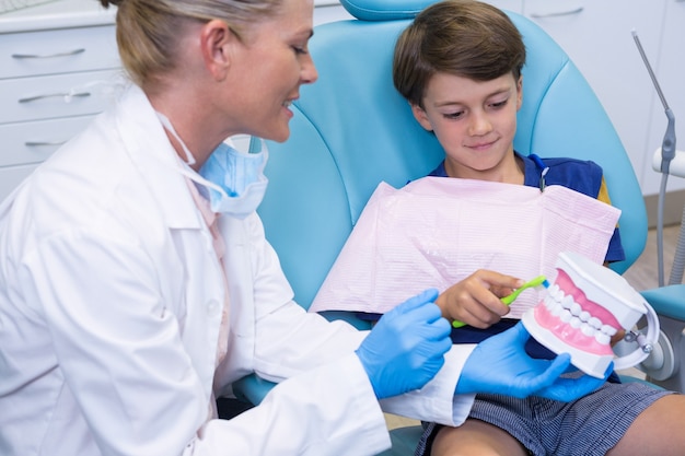 Doctor teaching boy brushing teeth