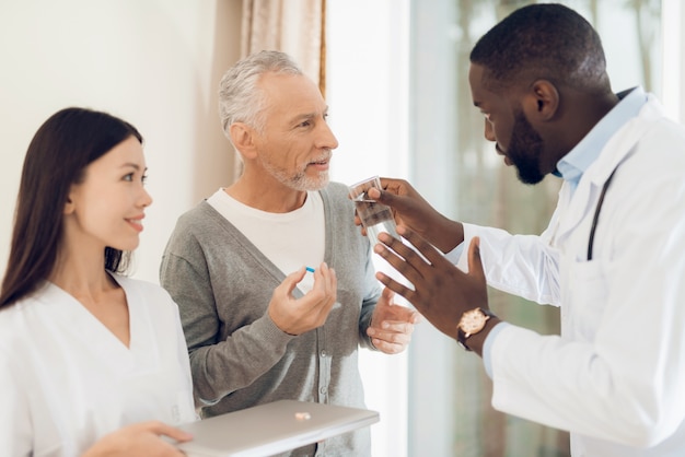 Doctor tells nurse how an elderly patient should take pills 