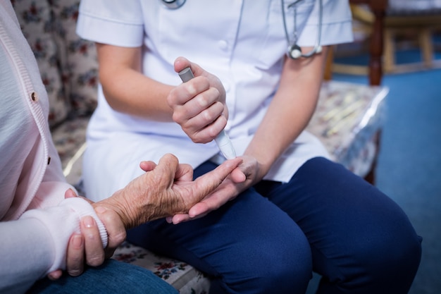 Doctor testing a patients glucose level using a digital glucometer