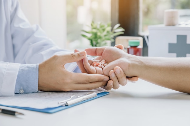 Doctor took the medicine for the patient and recommend treatment methods at consulting room