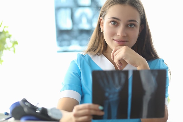 Doctor traumatologist holding xray of hand in clinic